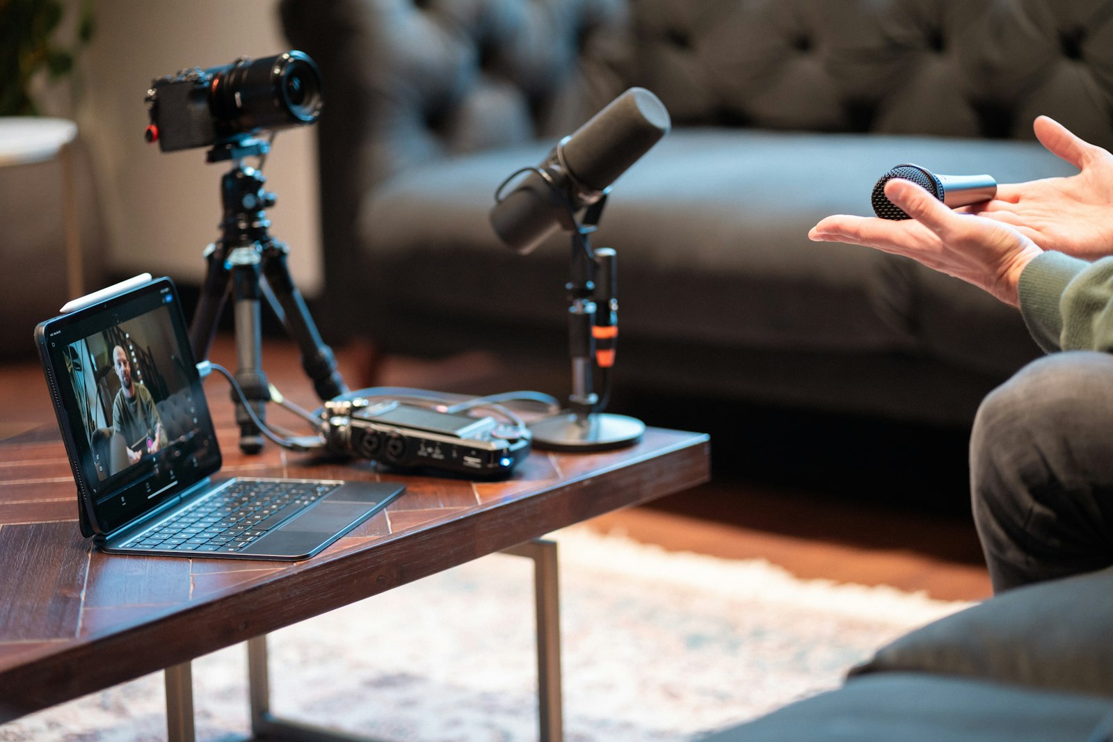 A podcaster's recording setup with a camera, audio interface, and microphone